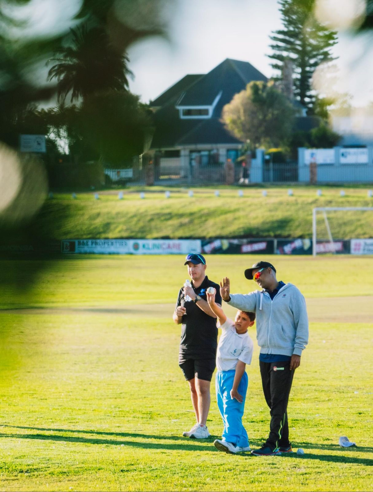A Unicorn coach guiding a young player on the field at golden hour